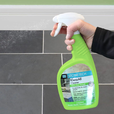 Hand spraying KlenzAll Heavy Duty Cleaner For Stone And Tile, Grout And Masonry, 24 Oz Spray Bottle, Breaks Down Tough Dirt And Grease