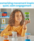 Child holding green Seasonal Sensory Tube For Calming Kids, Chill Out Fidgets For Travel And School, with other tubes on table