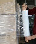 Heavy Duty Industrial Clear Stretch Wrap 4 Rolls 15 Inch Wide By 1000 Feet 80 Gauge Workhorse Grade applying to stacked boxes.