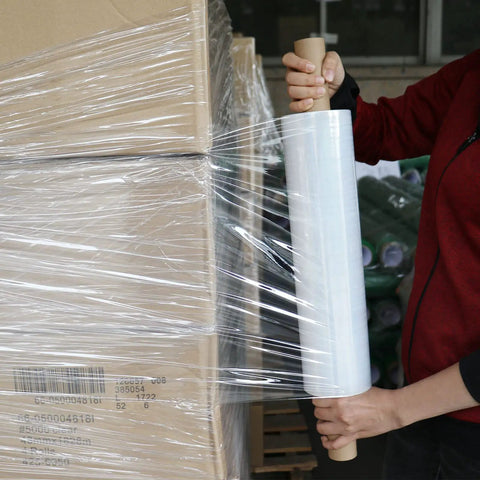 Heavy Duty Industrial Clear Stretch Wrap 4 Rolls 15 Inch Wide By 1000 Feet 80 Gauge Workhorse Grade applying to stacked boxes.