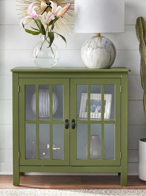 Green cabinet with glass doors, floral vase, lamp, and decorative items, adding style to modern interiors.