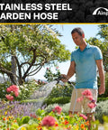 Person using Built To Last Tough As Nails Stainless Steel Garden Hose 100 Feet With Sprayer and Nozzle in a flower garden.
