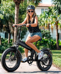 Woman riding Kickin Folding Electric Bike For Adults With 1200W Peak Motor 48V 15Ah Removable Battery under palm trees