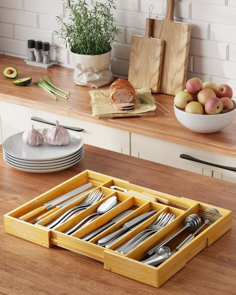 Expandable Bamboo Silverware Organizer For Drawers, Ultra Roomy 6 To 8 Slot Utensil Tray on kitchen counter with utensils