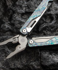 Camouflage Titanium Multitool Pliers Built Beefy With 420 Stainless Plier Head And 440 Steel Accessories on black rock