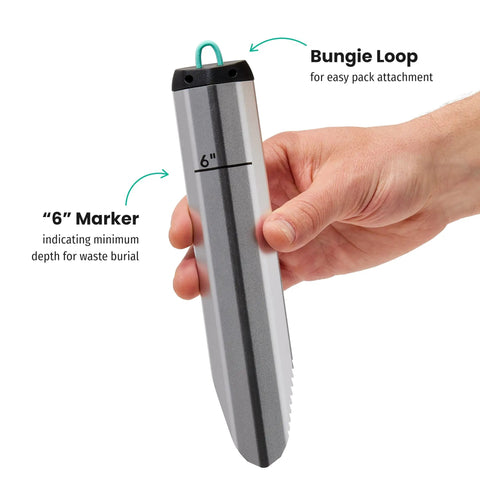 Hand holding Award Winning Ultra Lightweight Aluminum Backpacking Shovel For Camping And Hiking Ergonomic Trowel with 6 inch marker
