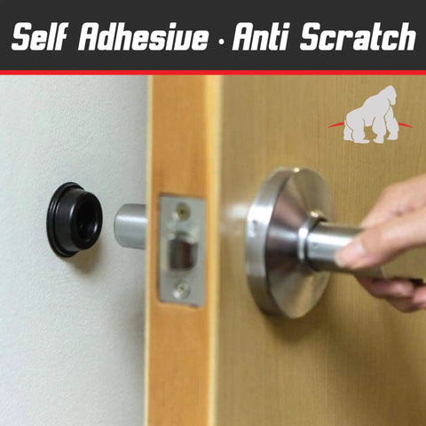 Soft Rubber Door Stopper Bumpers Pack Of Four Black Self Adhesive Wall Protectors To Stop Wall Dings From Doorknobs And Handles Cushion And Quiet Your Doors With Noise Dampening Protection shown installed behind a door handle preventing wall damage.