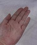 Hand touching fiberglass screen roll for windows and doors, high visibility flexible mesh for easy DIY repair and rescreen.
