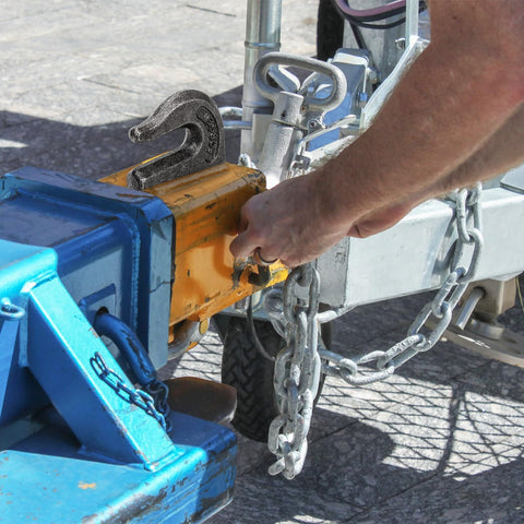 Man securing trailer with Six Pack Weld On Grab Hooks Three Eighths Inch Tow Chain Hooks G70 Forged Clevis Weldable Hooks