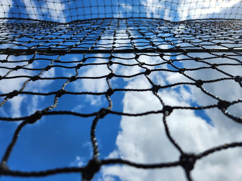 Close-up of Batting Cage Net For Baseball And Softball Practice, HDPE Netting With 42 Twine against blue sky background.