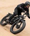 Rider on Beast 6000W Dual Motor Ebike for Adults with 24 inch fat tire and lockable suspension on sandy terrain