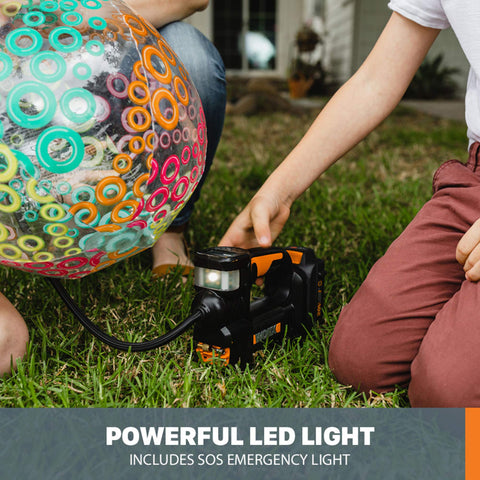 Person using Cordless Tire Inflator With Digital Gauge On The Go Portable Air Pump to inflate a colorful ball on grass
