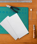3 Pack White PTFE Teflon Sheets 12 x 6 Inches, One Sixteenth Inch Thick shown on a crafting table with tools