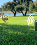 Solar Ultrasonic Animal Repellent With Motion Sensor Waterproof IP65 Outdoor Pest Deterrent set in grass near a lake, with rabbits fleeing
