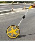 MZZKFC Portable Distance Measure Tool for Confined Space Measurements, aluminum alloy, foldable, on a road surface.