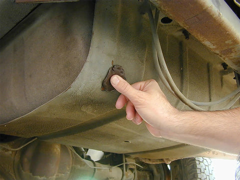 Hand applying Instant Gas Tank And Radiator Repair Epoxy Putty That Grips Wet Surfaces, Steel Reinforced to car tank