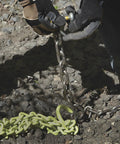 Close-up of Heavy Duty Triple Chain Shrub And Clump Remover Tool on rocky ground, showing chain details and connection.