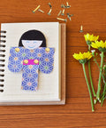 500 Piece Mini Brass Paper Fasteners Gold Pin Backs with paper doll on notebook and yellow flowers for crafting.