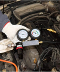 Automotive dual-gauge cylinder leak-down tester kit by Amazon, connected to car engine with orange hose.