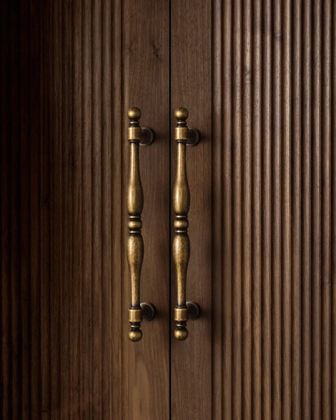 Six Pack Antique Brass Cabinet Pulls With 7.6 Inch Hole Center on wooden cabinet doors, vintage look, two handles shown.