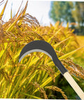 Heavy Duty Weeding Scythe With Long Handle For Garden Weeding And Cultivating, Manganese Steel Blade, Comfortable Grip shown in a field