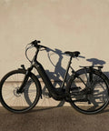 Electric city bike leaning against wall, ideal for everyday rides and off-road adventures with multi-fit inner tube compatibility.