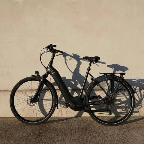 Electric city bike leaning against wall, ideal for everyday rides and off-road adventures with multi-fit inner tube compatibility.