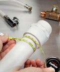 Diameter Measuring Pocket Sized Tape Measure 6mm By 2m Dual Sided Blade measuring a white pipe on metallic surface