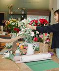 Florists arranging blooms with Pearlescent Lit Floral Wrapping Paper Set Breathable Cuttable Bouquet Wraps 20 Sheets nearby