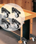 Smooth As Silk Retractable Workbench Casters 4 Pack Heavy Duty Swivel Wheels with step pedal on wooden workbench.