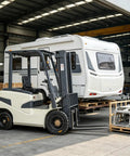 Built Tough Electric Warehouse Forklift And Plug And Play Battery Stacker lifting crates in a spacious warehouse with a trailer.