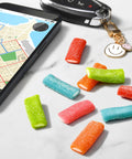 Mixed Fruit Rope Bites Candy in a reusable 8 ounce bag with chewy tart filling displayed on a table with smartphone and keys.