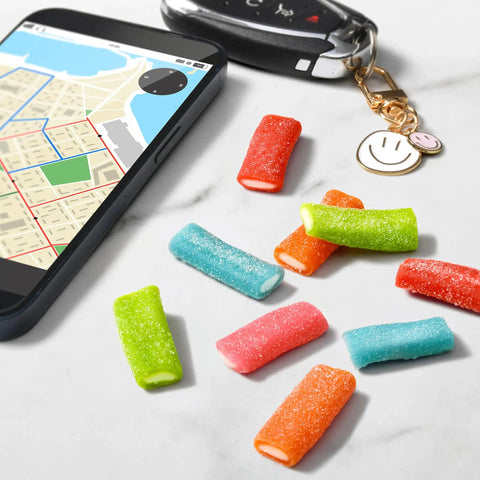 Mixed Fruit Rope Bites Candy in a reusable 8 ounce bag with chewy tart filling displayed on a table with smartphone and keys.