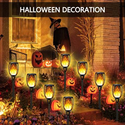 Outdoor Solar Torch Lights Set With 96 LED Beads illuminating a yard with Halloween decorations, showing dancing flame effect.