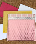 Rose Color Air Bubble Mailers Padded Envelopes Self Seal 25x20cm with red, yellow, and white envelopes on cork background.