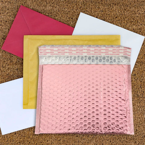 Rose Color Air Bubble Mailers Padded Envelopes Self Seal 25x20cm with red, yellow, and white envelopes on cork background.