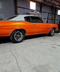 Showroom Smooth Dreamsicle Orange Basecoat Paint Gallon Ready To Spray Mix With Slow Reducer For Zero Hassle Street Car Restorations And Bumper To Bumper Shine on classic orange muscle car in workshop.