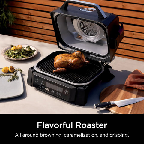 Woodfire Outdoor Grill And Smoker With Four In One Functionality For Real Woodfire Flavor And Sear Crave Ready Backyard Grilling Bake And Roast All In One Electric Heat OG301 in use with roasted chicken.