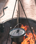 Rugged Heavy Duty Steel Camping Tripod For Open Fire Cooking suspending a Dutch oven over flames, 43.3 inch tall stand.