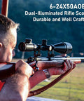 Man aiming a rifle outdoors, equipped with a Versatile 6-24x50 AO Rifle Scope With Illuminated Red Green Reticle Long Eye Relief 20mm Mount