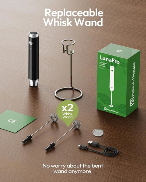 LunaFro Handheld Milk Frother with stand, box, detachable beaters, and USB-C cable on a table, showcasing replaceable whisk wand.