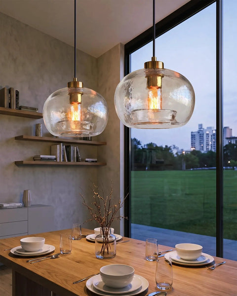 CASAMOTION Glass Pendant Lights, Textured Clear Globe Shade illuminating a dining table with a modern design.