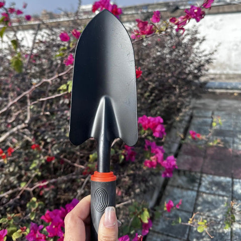 Heavy Duty Garden Trowel With Comfort Grip Oversized Aluminum Alloy Hand Shovel held above colorful flowers outdoors