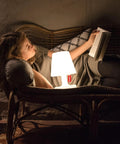 Woman reading by Tiny Rechargeable LED Lamp 2.0 Go Anywhere Dimmable Table Light For Indoor And Outdoor Use Bright 58 Lumens