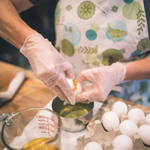 Top Shelf Clear Vinyl Disposable Gloves Straight Up Reliable 3 Mil Thickness Light Industrial Grunt Work Friendly Food Safe Latex Free Powder Free Large Size Box Of 100 For Daily Shop Tasks used while cracking eggs in the kitchen.
