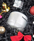 Hassle Free Black Crinkle Cut Paper Shred Filler For Gift Baskets And Boxes with festive decorations and a candle.