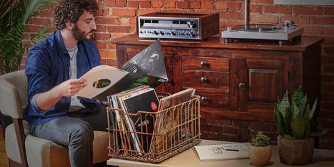 Person inspecting vinyl records near Audio-Technica At-Lp120Xusb-Bk Direct Drive Turntable Analog And USB Fully Manual Hi-Fi 3 Speed.