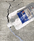 Heavy Duty Roof Sealant And Exterior Coating Delivers A Hella Tight Waterproof Barrier For Fast Crack Repairs With Zero Fuss On Interior Walls Floors And Roofs Around Any Home Or Garage, shown in pouch over concrete crack.
