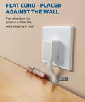 Three Outlet Extension Cord With Flat Plug For Home Or Office plugged into wall socket, showing flat design against wall.