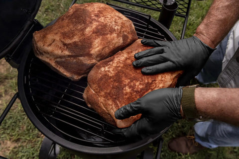 Grill Ready Disposable BBQ Gloves Kit With 50 Nitrile Gloves, handling meat on a grill, showcasing heat resistance and protection.